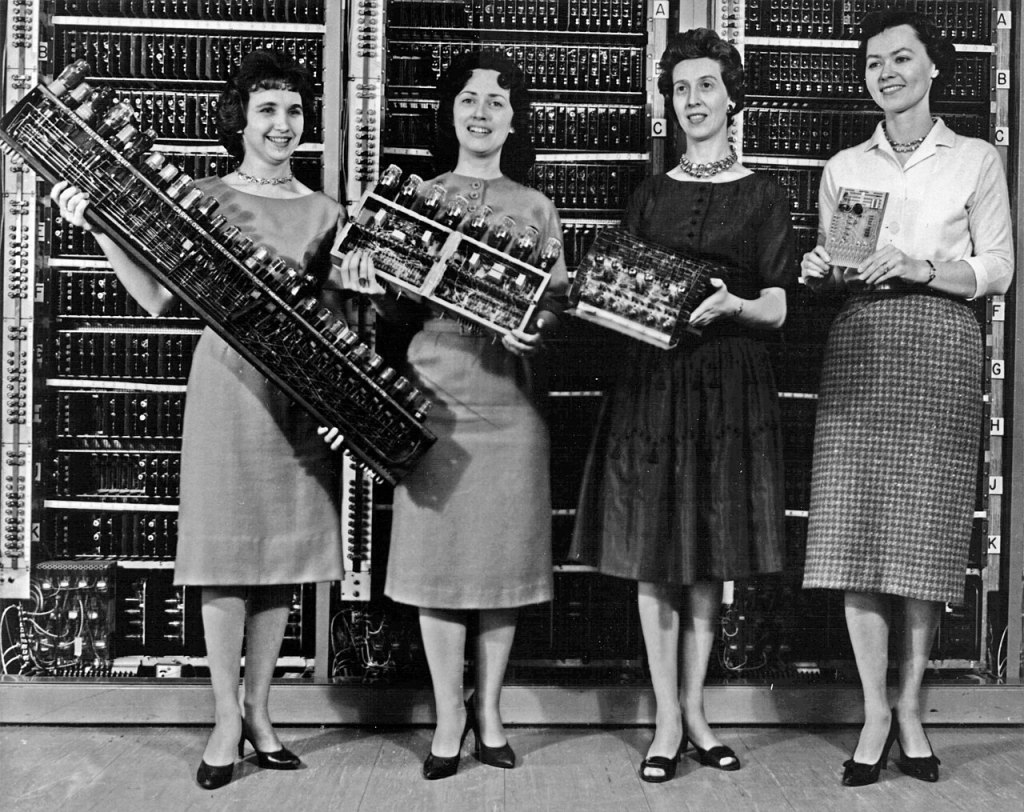 Women holding parts of the first army computer